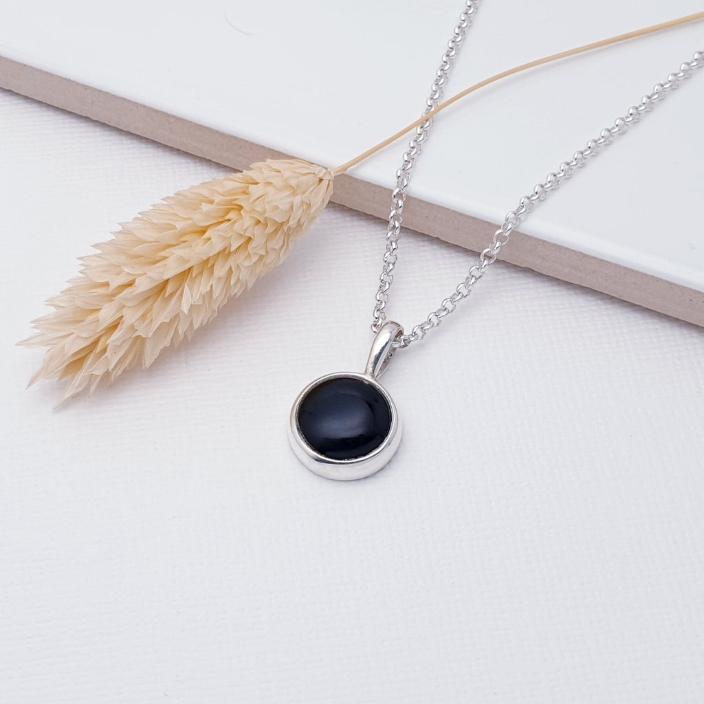 Our Onyx Sterling Silver Small Simple Round Pendant (chain not included) is perfect for everyday wear or special occasions.  This pendant features a cabochon, round, Onyx stone in a simple Sterling Silver setting. Small and simple, this little pendant is perfect for women and girls of all ages. Perfect worn on its own on a short chain, or layered with other necklaces to create your own unique look.