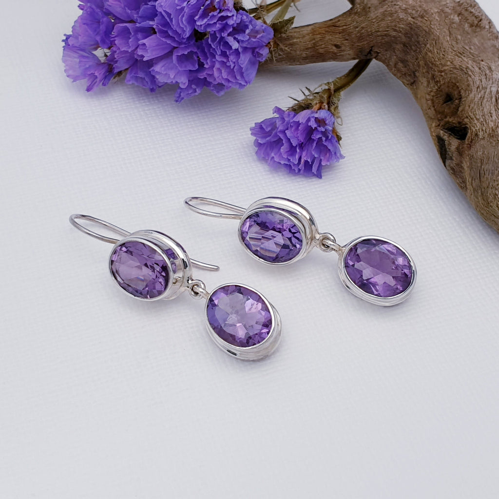 Double drop tabletop cut amethyst earrings with a chunky silver surround.