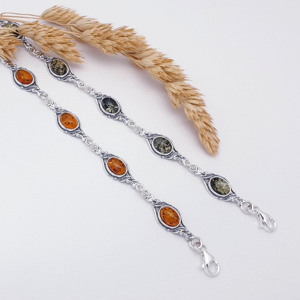 A toffee and green genuine amber vintage style bracelets, with sterling silver. Side by side with wheat foliage