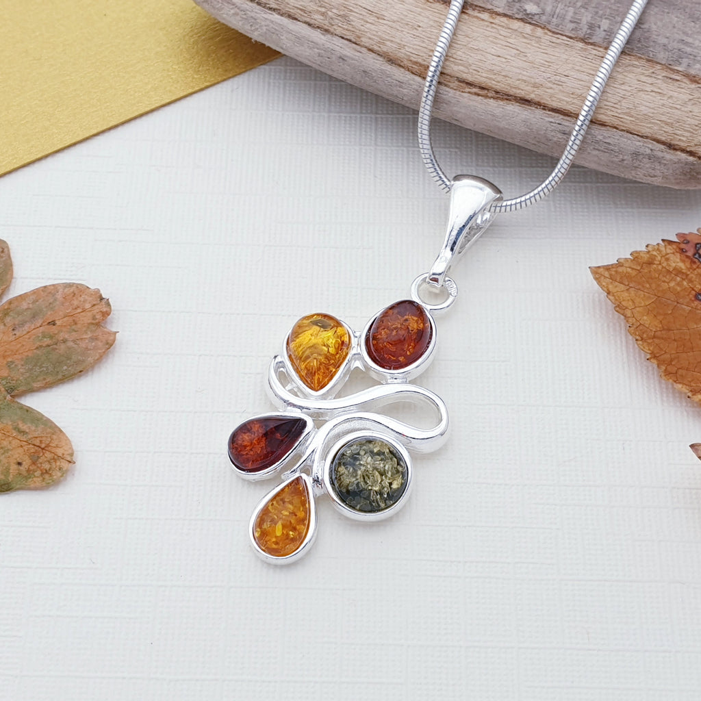 a silver mixed amber pendant on a chain