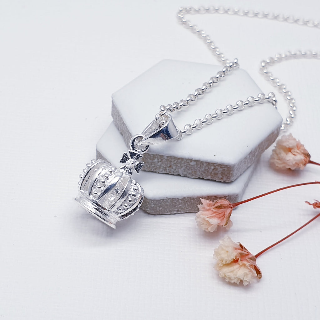 With an 'icing sugar' finish and gorgeous detailing, this pendant features a Silver crown design. Perfect to add a touch of royalty to your outfit.