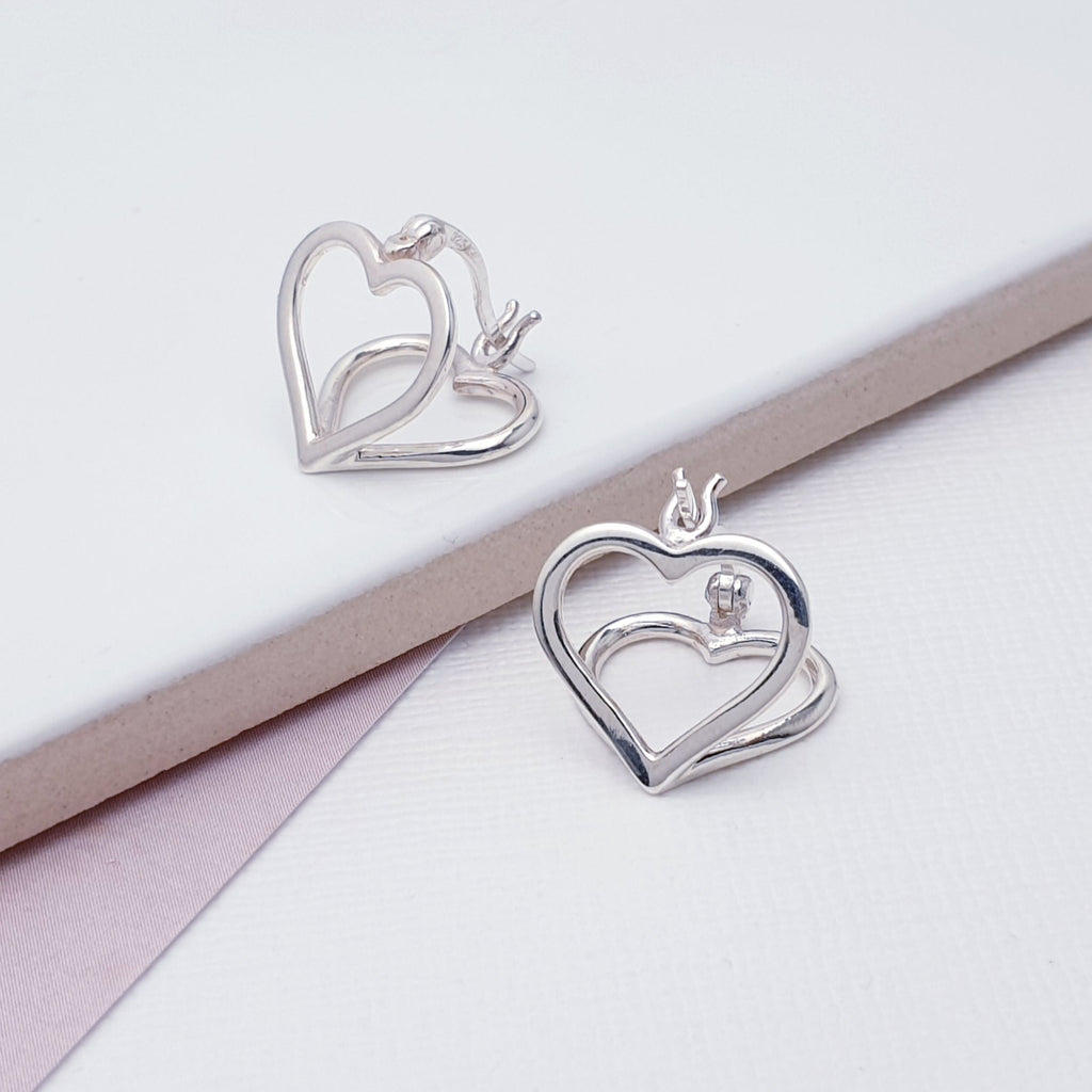 These earrings feature two Sterling Silver heart shapes, creating a two-way design. Hinged Snap fastening means that they are extra secure so you won't have to worry about loosing them.