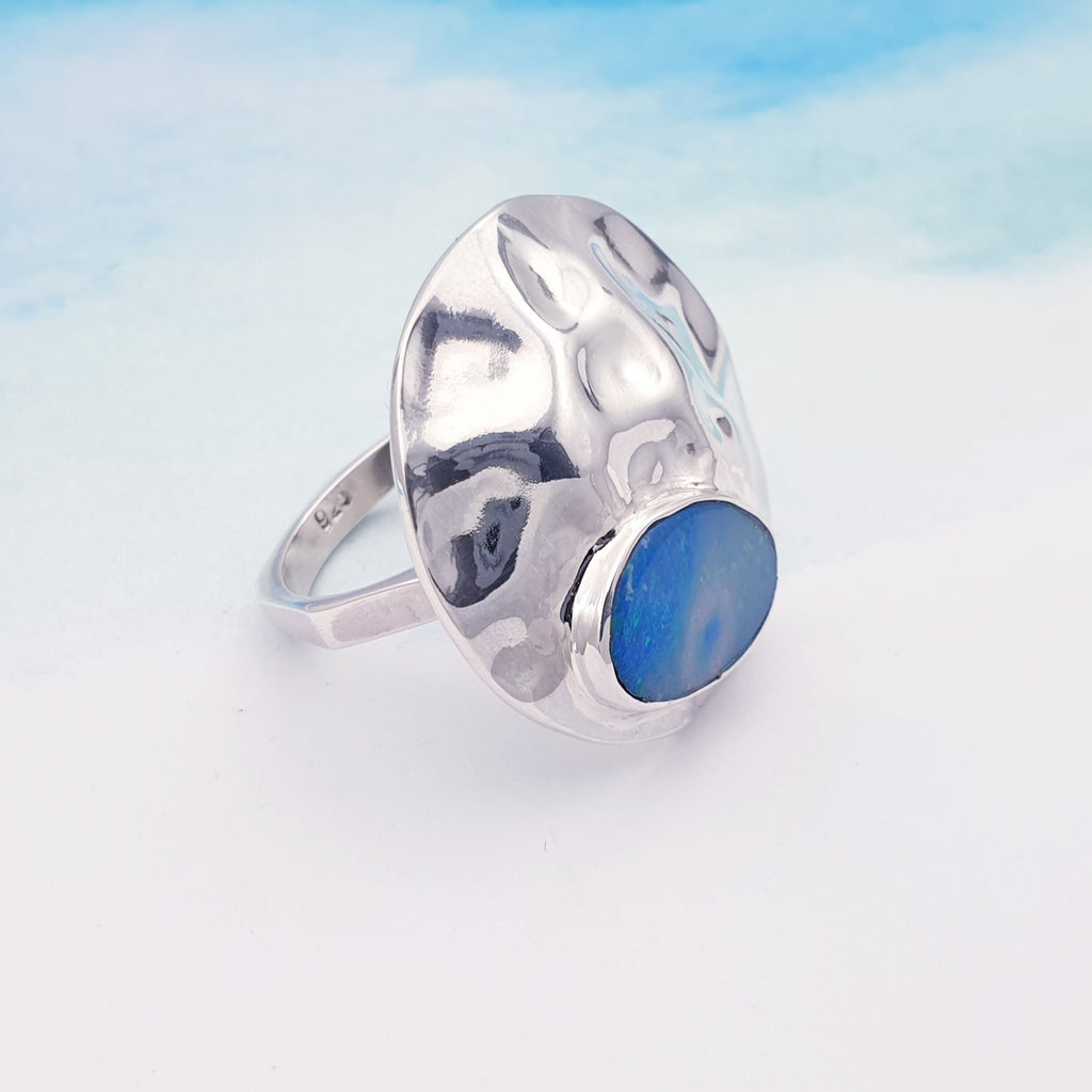 A beautiful design, this ring features a gorgeous free form Australian Opal doublet set in a Sterling Silver hammered circle.  A super statement ring perfect for adding a little sparkle to any outfit or occasion.