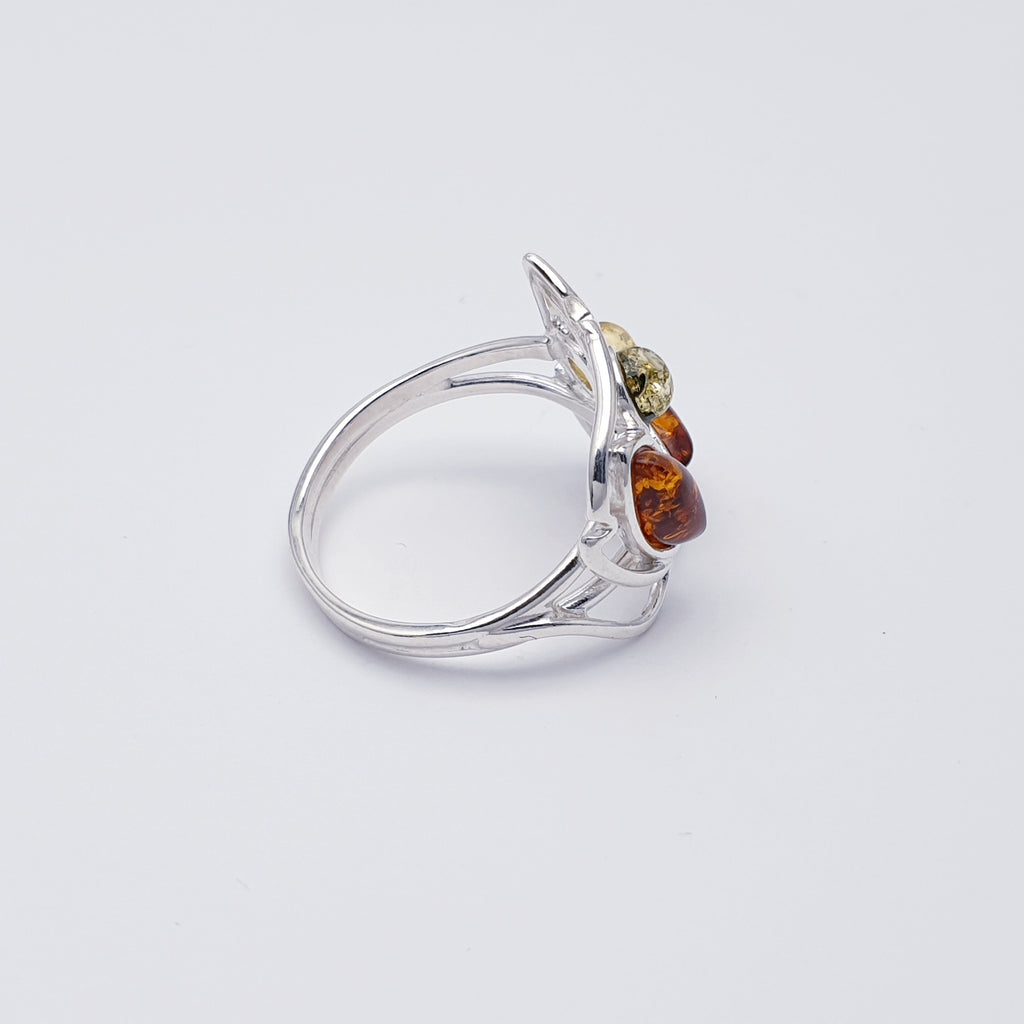 This ring features two marquise shaped Toffee Baltic Amber stone and two smaller round mixed Amber stones in simple settings. Inspired by nature, Sterling silver leaf detailing has been added around the amber stone to accentuate the shape. A fine sterling silver band finishes off this design perfectly.