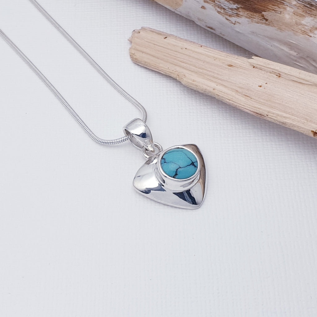A delicate design, this pendant features a Turquoise stone set in a solid Sterling Silver triangle shape. With a contemporary twist, this pendant will complement any outfit, day or night. 
