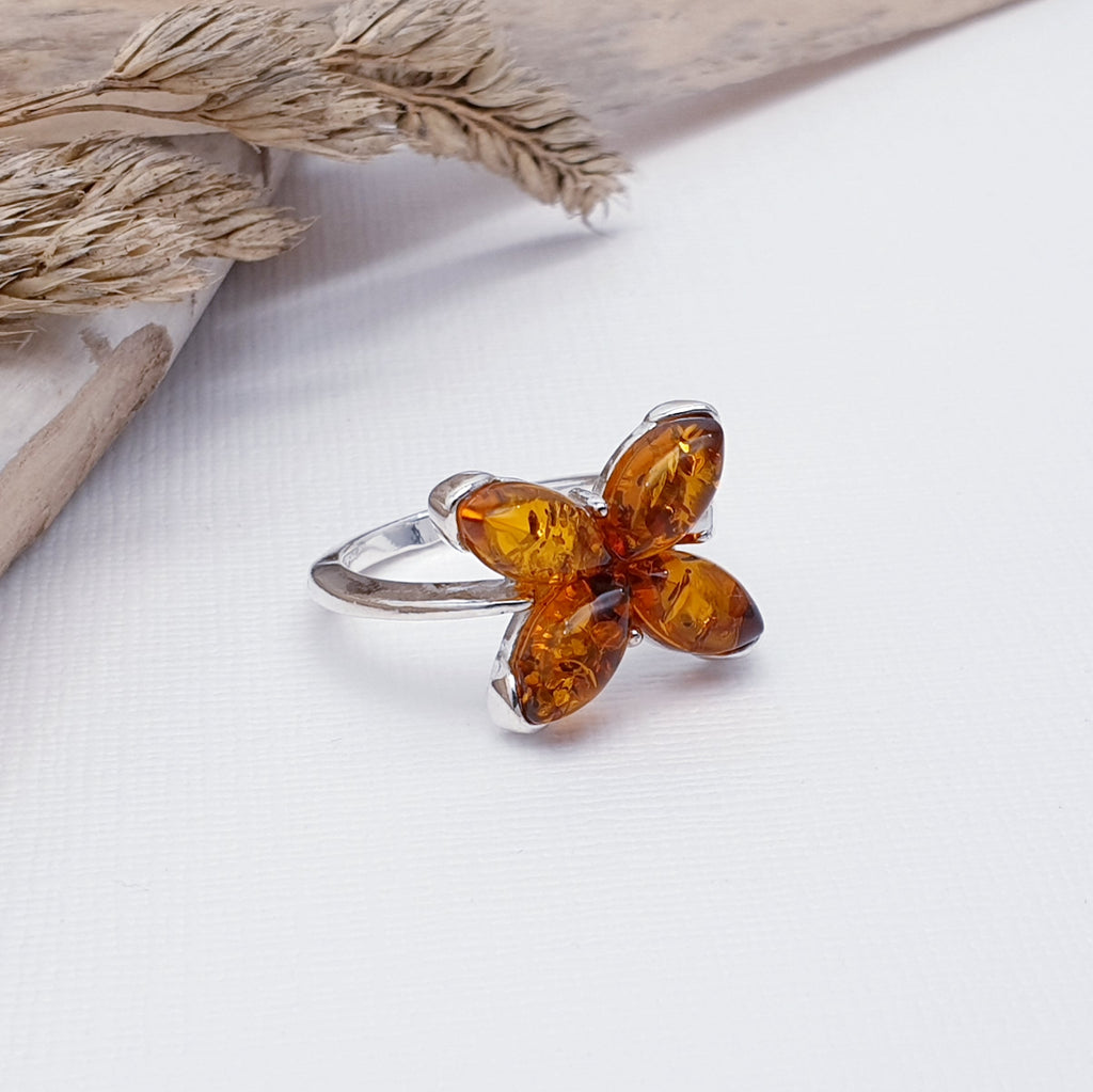 This gorgeous ring features four marquise shaped Baltic Toffee Amber stones in a simple setting.  The Amber stones have been beautifully crafted into a gorgeous 3D star flower shape. A comfortable design, this ring is perfect for everyday wear and is bound to become a well loved piece of jewellery.