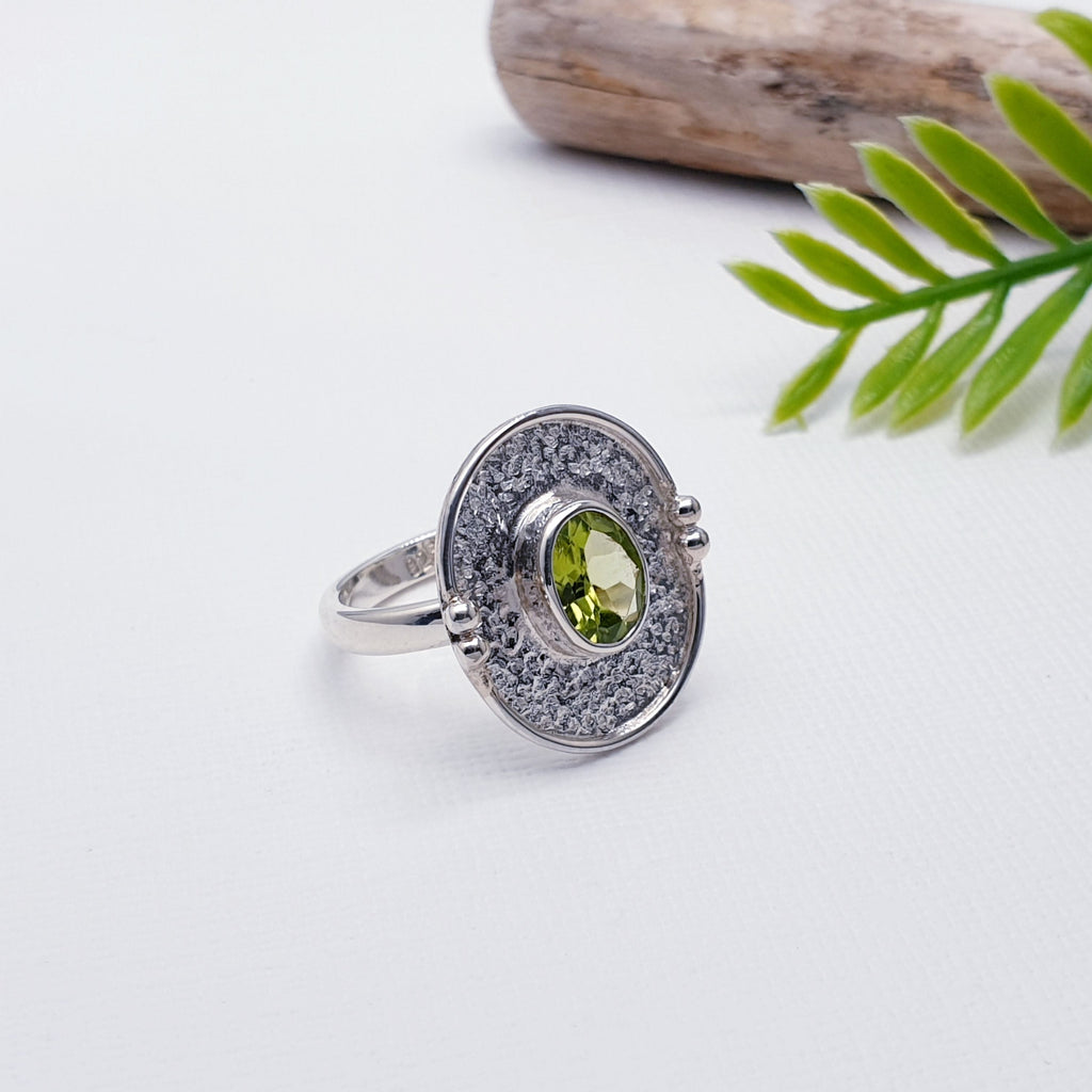 Our Peridot Oya Ring is a Silver Scene top seller and is perfect for everyday wear or special occasions.  This ring features a beautiful oval shaped tabletop cut  Peridot in a simple setting. The stone is placed in the centre of a hammered, Sterling silver oval shield with added silver detailing. A unique design, you won't find this ring anywhere else.