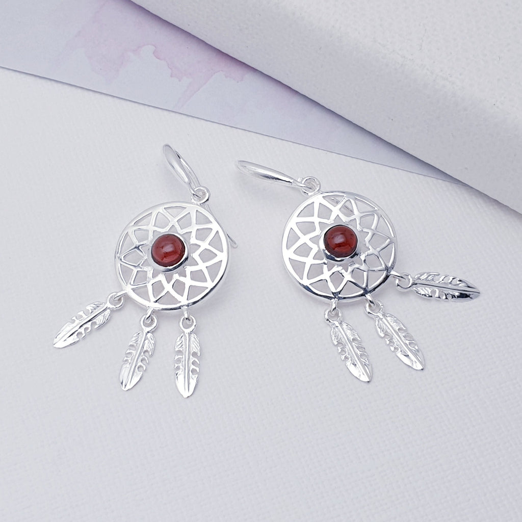 Our Garnet Sterling Silver Dream Catcher Earrings are perfect for everyday wear or special occasions.  These stunning earrings features small, cabochon Garnets in the center of a beautifully detailed dream catcher, with three dangly feathers.