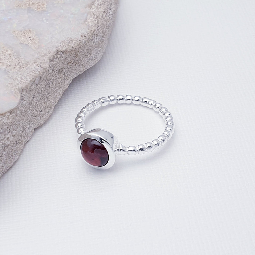 Our Garnet Bubble Band Ring is perfect for everyday wear or special occasions.  A beautiful design, this ring features a stunning, round, cabochon, Garnet stone in a simple lowered setting. The band is shaped in a bubble-like ball design, to add extra detailing.