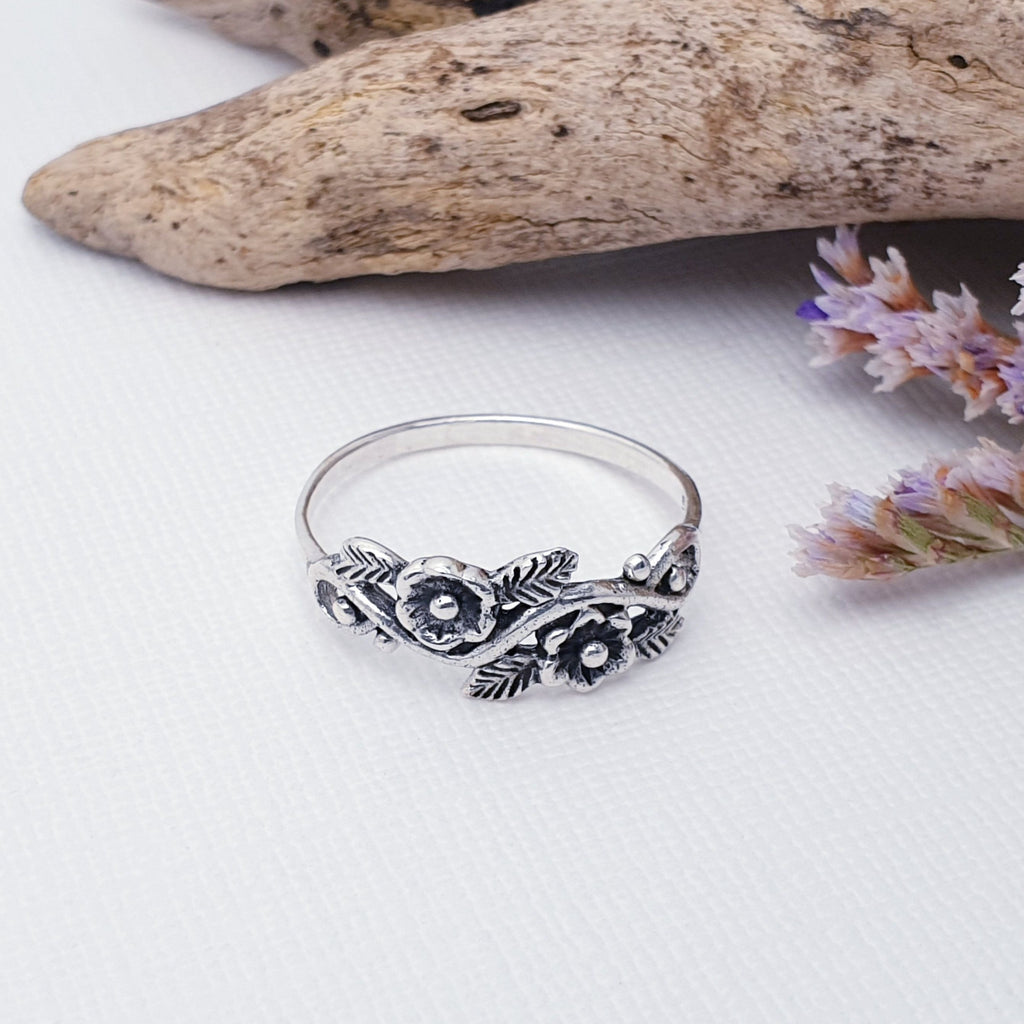 Our Sterling Silver Flowers on Vine Ring is perfect for everyday wear or special occasions.  A beautiful design, this ring features stunning, detailed flowers that wrap comfortably around the finger, and is given depth with the use of oxidisation. The perfect combination of modern and vintage style, this ring will become an instant wardrobe staple.