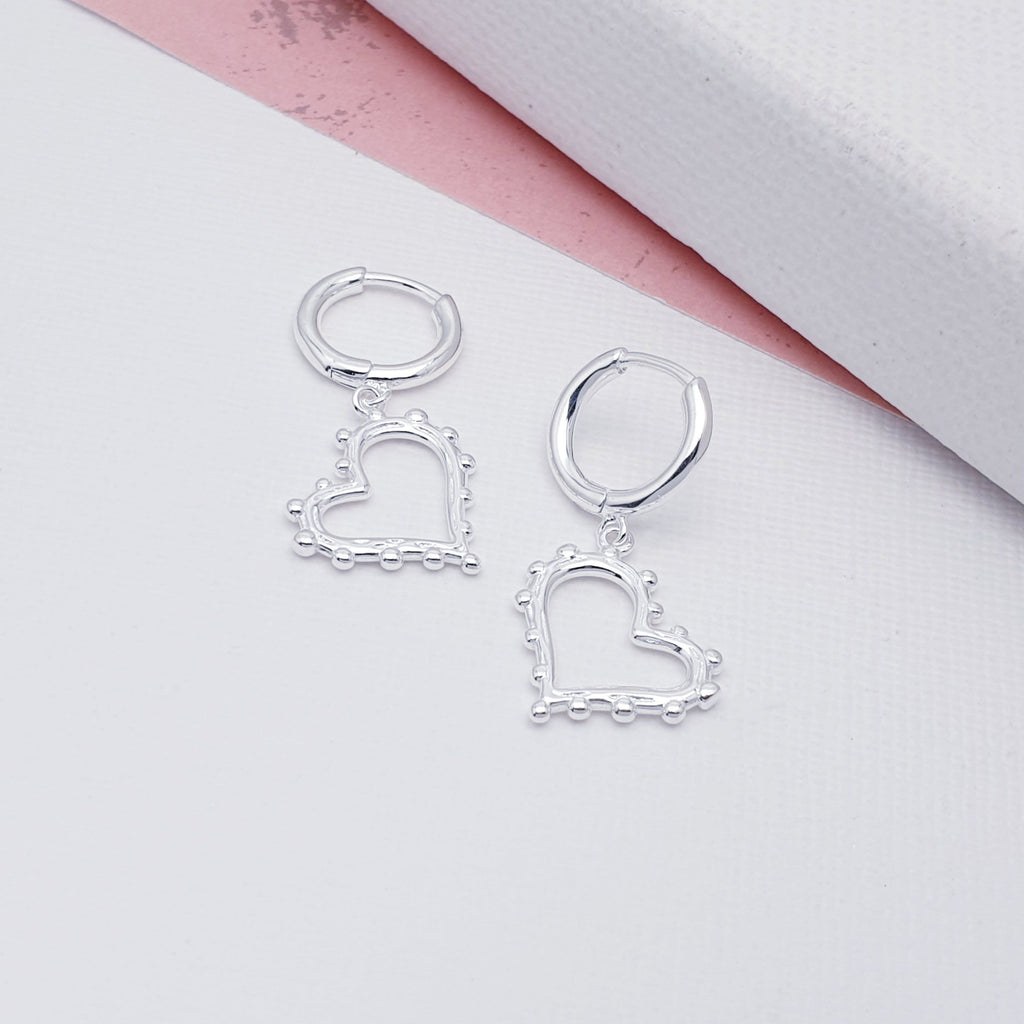 A refreshing twist on the classical heart design, these earrings are dainty and easy to wear. Each earring features an  intricate silver heart decorated with silver balls hanging from a simple silver hoop. Perfect for work or play, these earrings will soon become everyday favourites.