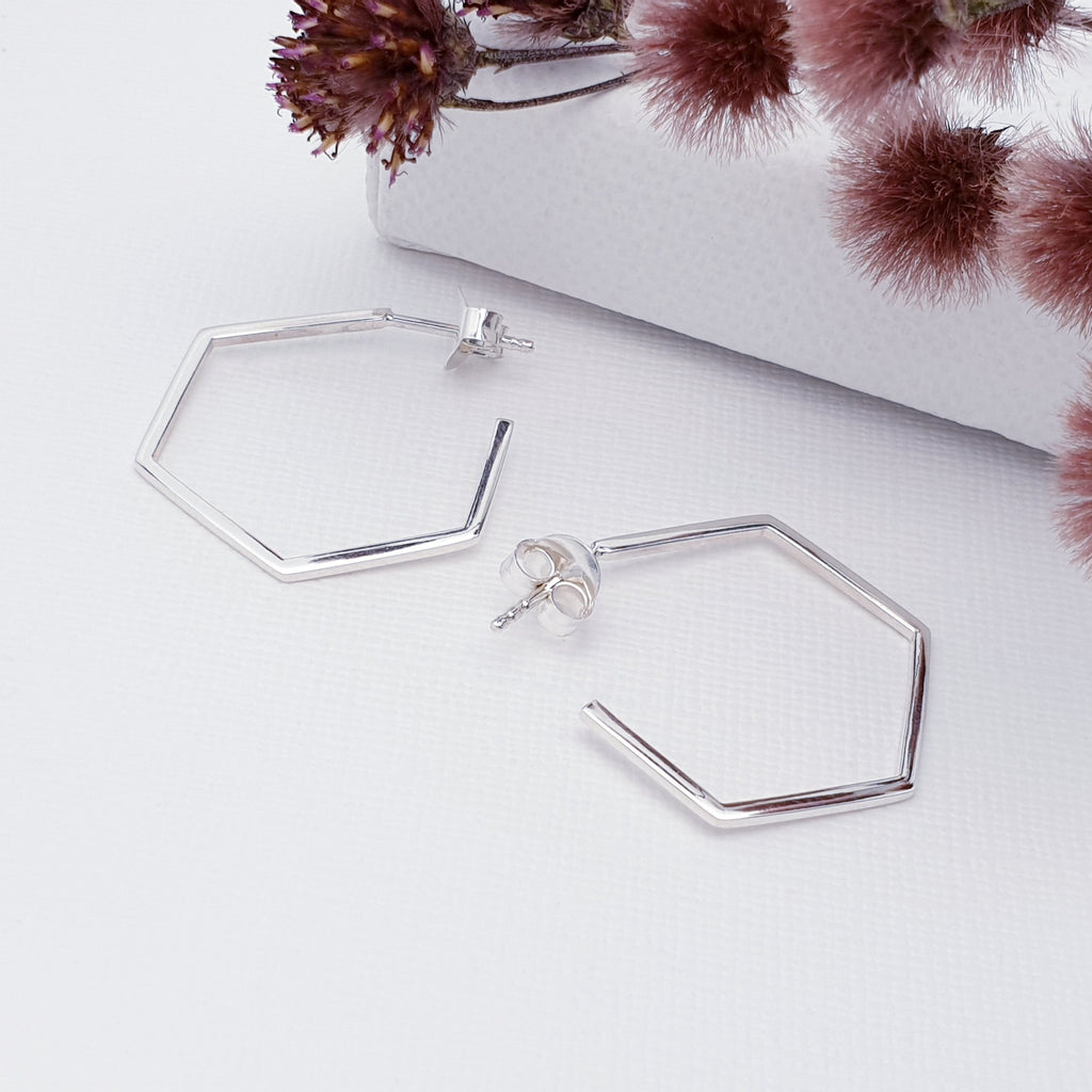 This design features Sterling Silver hexagonal half hoops, ideal for work or day wear. The stud fixing makes these earrings extra secure so you don't need to worry about losing them.