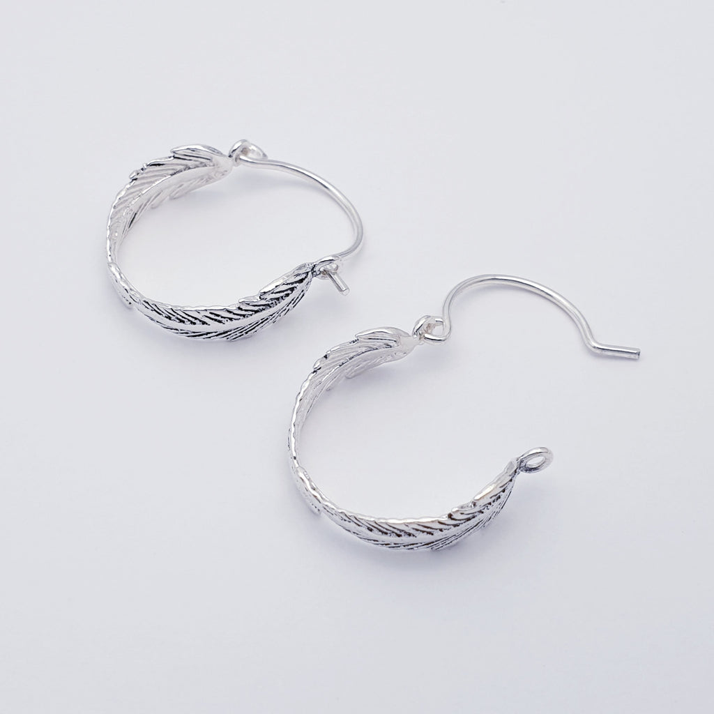 a pair of small sterling silver feather hoops