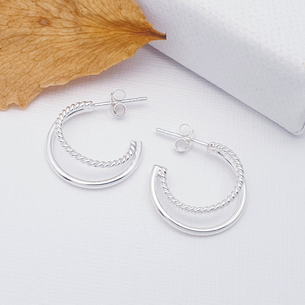 sterling silver rope design half hoops flat lay with foliage