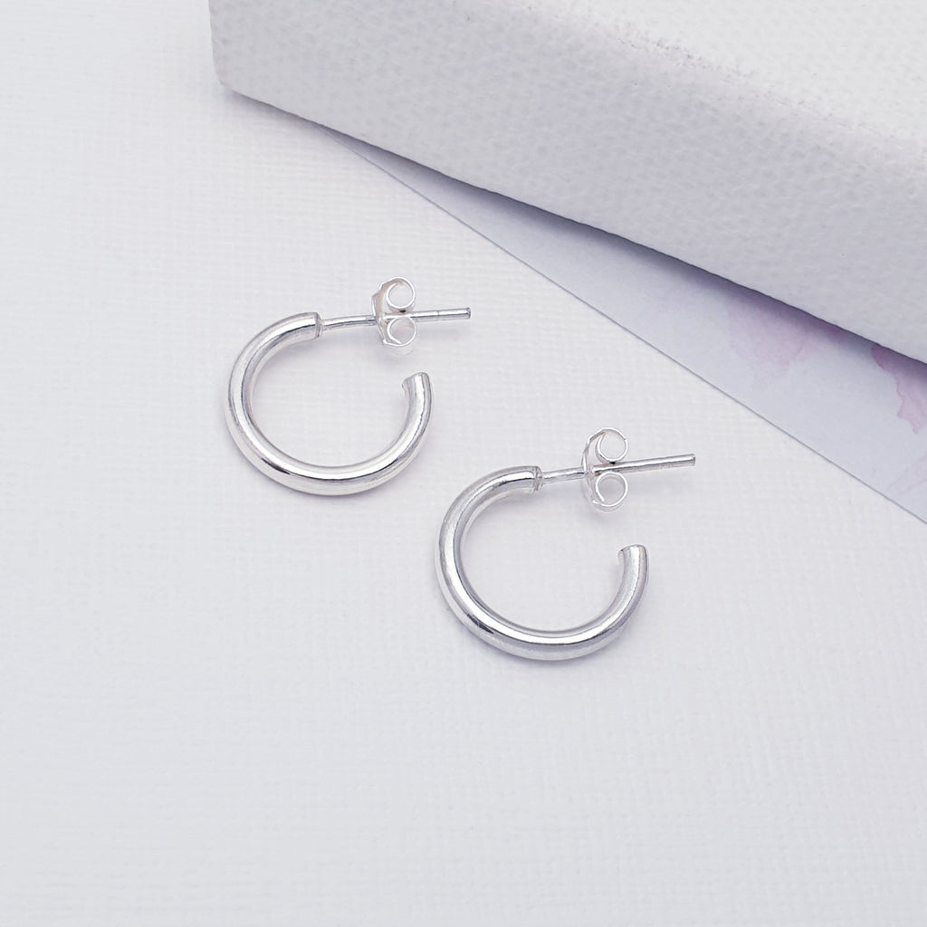 Simple silver half hoops with stud attachment, displayed on white background