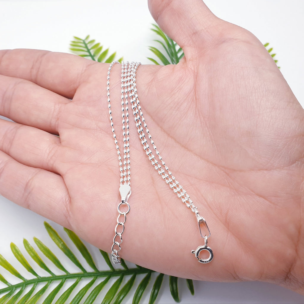 Delicate, adjustable sterling silver bracelet with three strands of tiny oval beads on a fine chain.