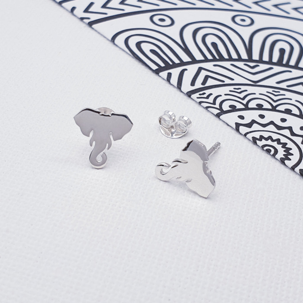 A pair of elephant silhouette studs displayed on a white background with a mandala detail 