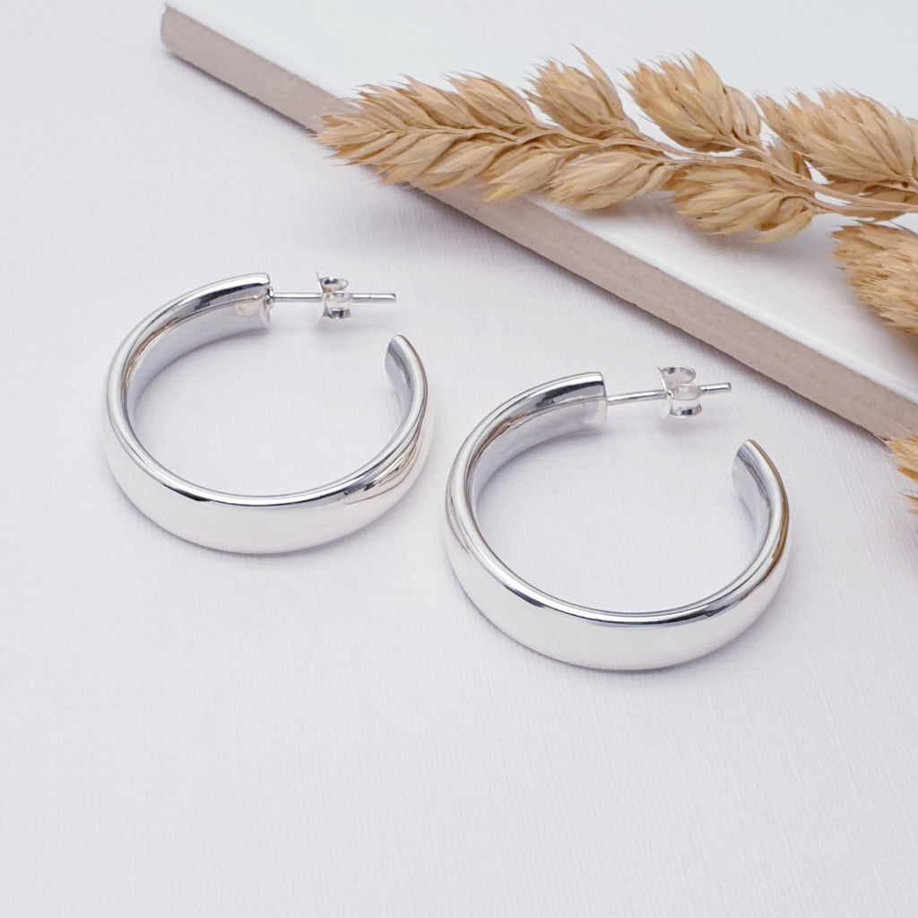 Silver half hoops on a white background with a detailing of wheat