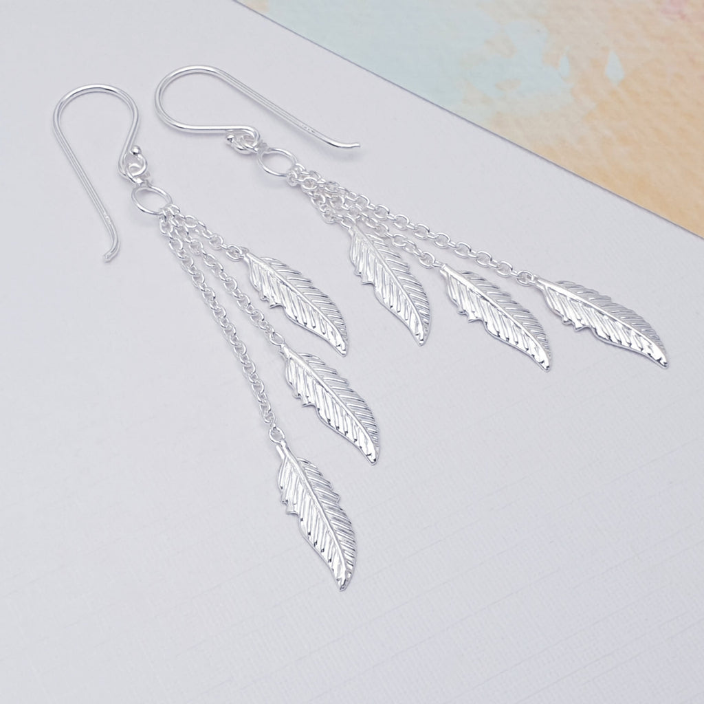 Sterling Silver Multi Feather Earrings on a white background with coloured card in the top right corner