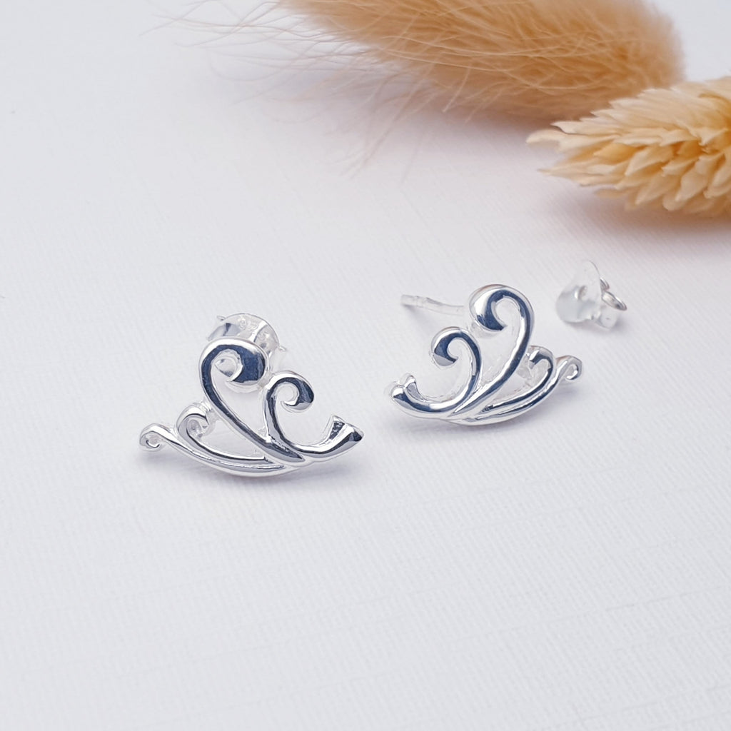 Our Sterling Silver Sea Breeze studs displayed on a white background with autumnal leaves in the background as decoration
