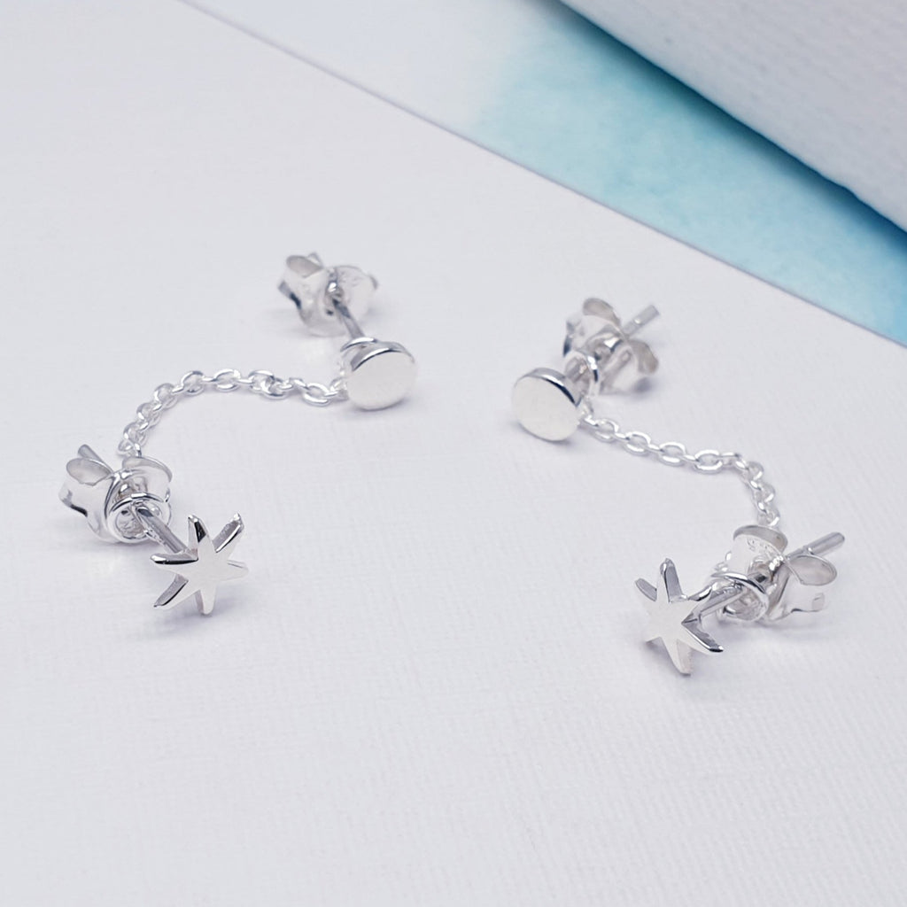 Our Celestial double studs displayed on a white background with blue card  towards the back of the picture as decoration