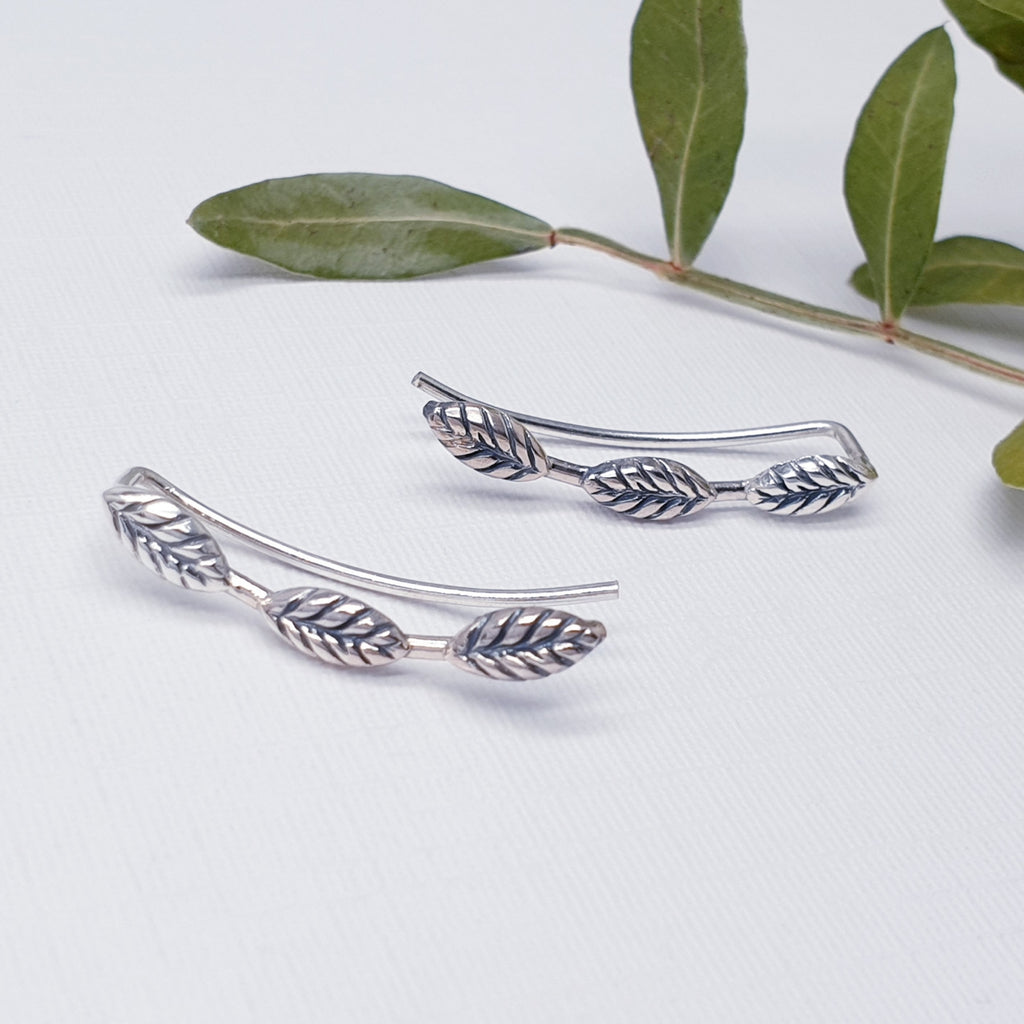 Our Triple leaf ear climbers displayed against a white background with green leaves as deoration