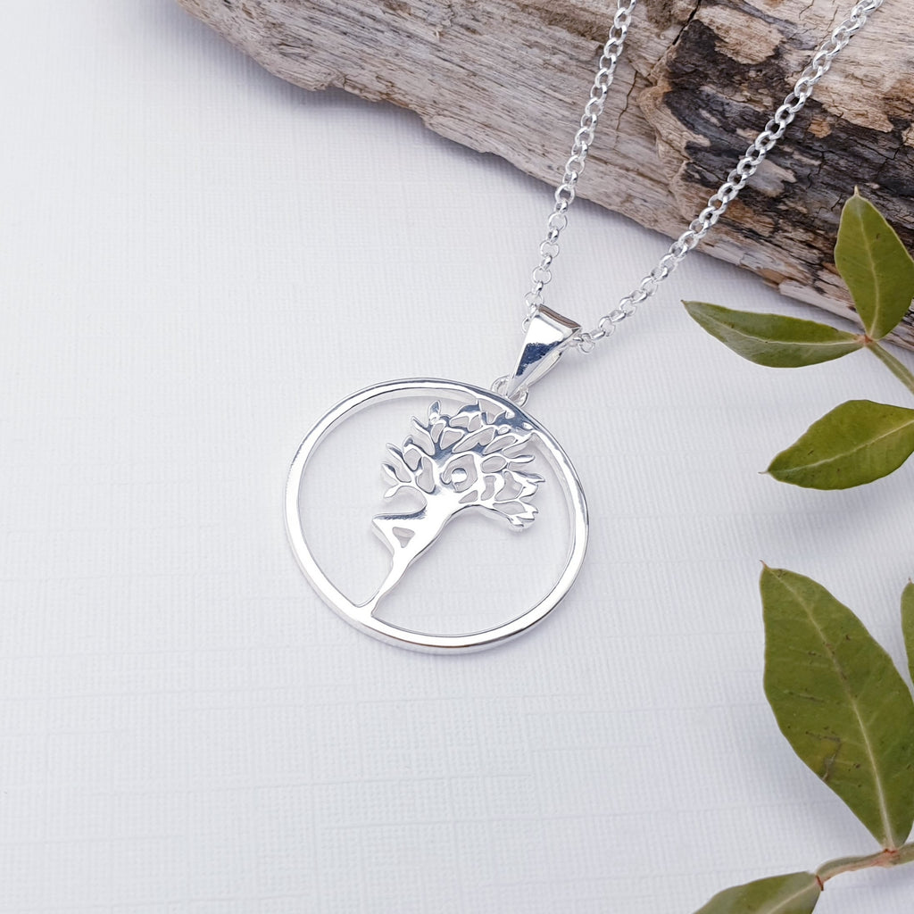 Silver tree of life pendant on a chain with a natural background