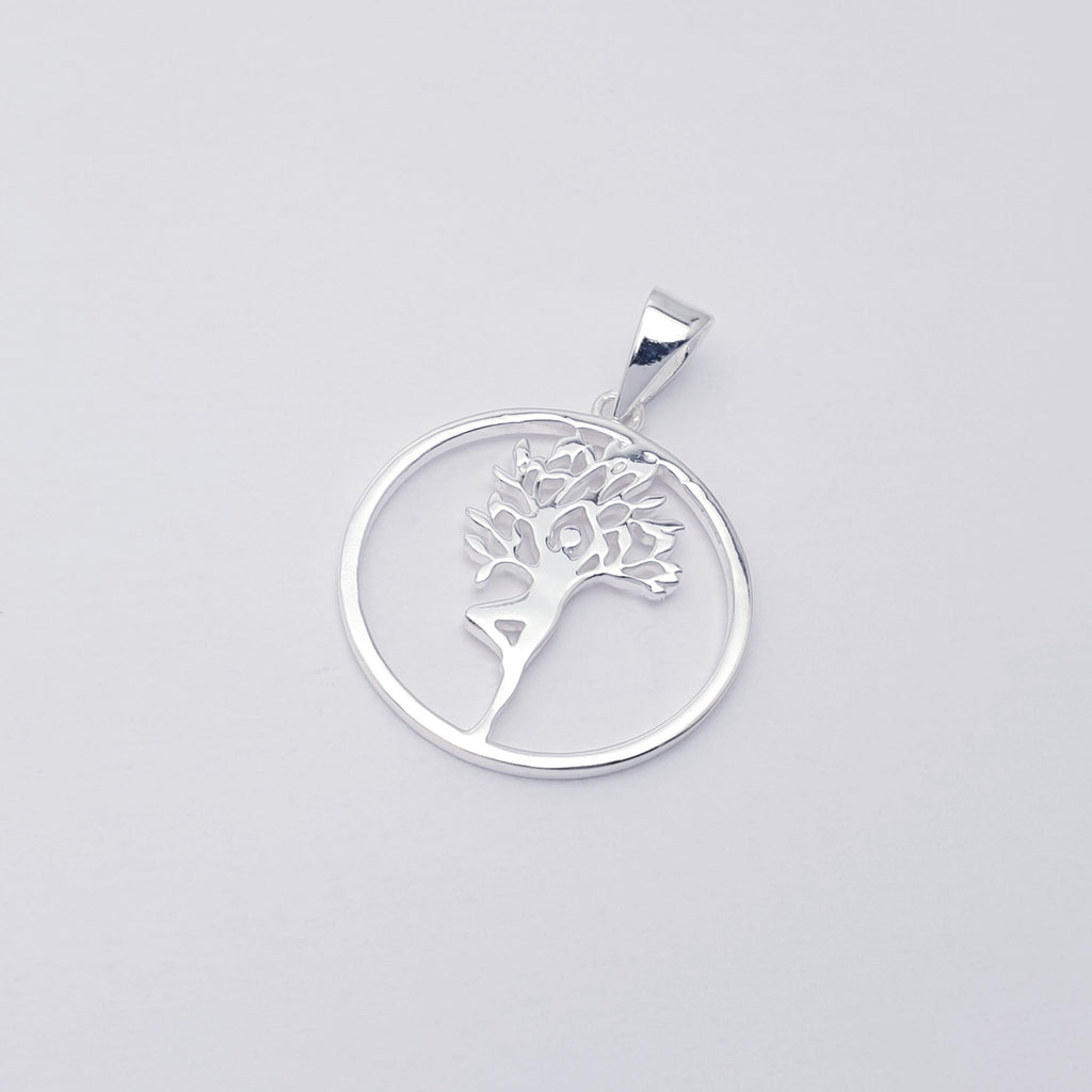 Silver pendant with tree design on a white background