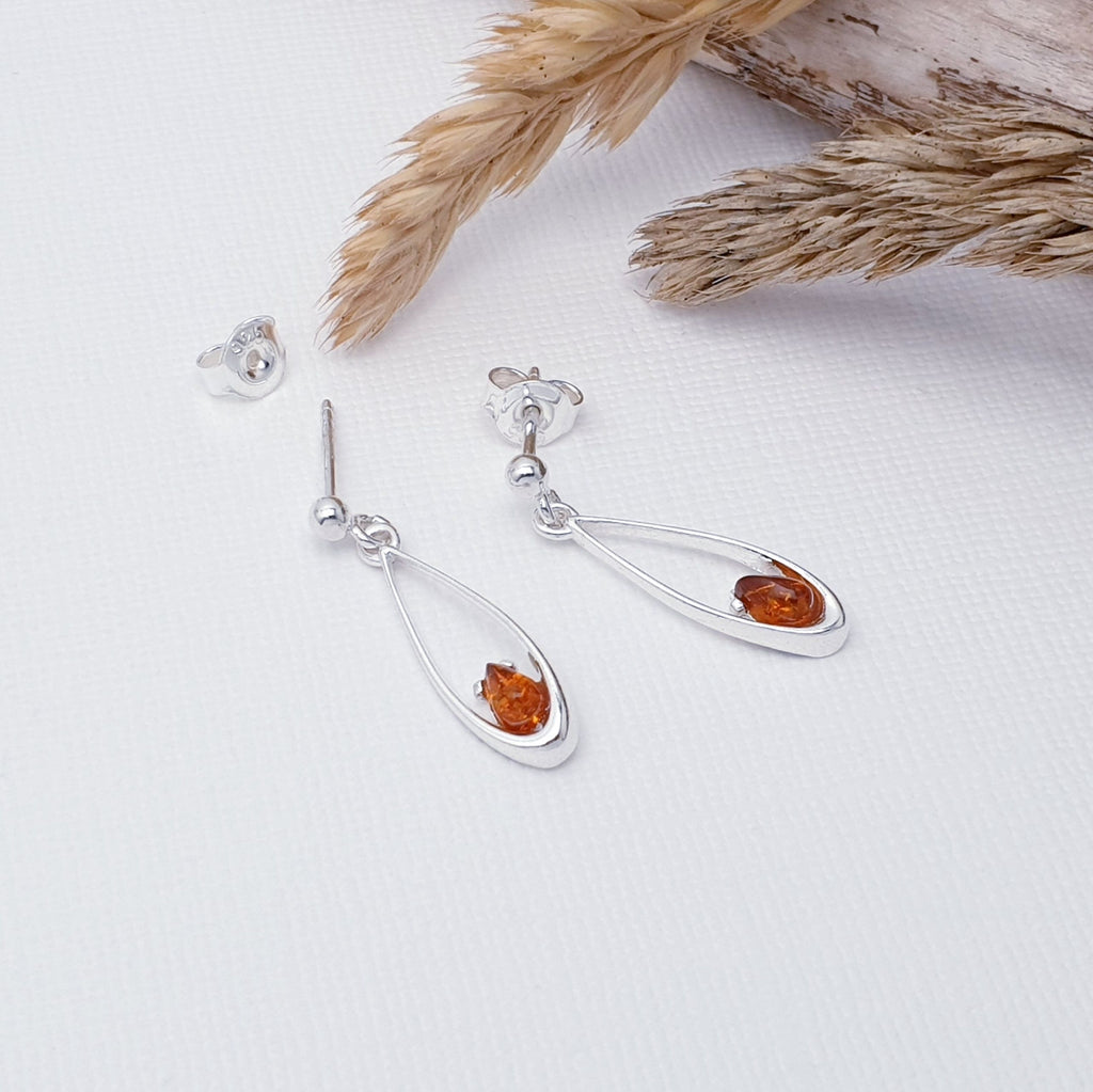 Our Toffee Amber Sterling Silver Petit Drop Stud Earrings are perfect for everyday wear or special occasions.  Simple yet eye-catching, each earring features a teardrop shaped toffee amber stone. The stone is held in Sterling Silver that curves elegantly up the stone. 