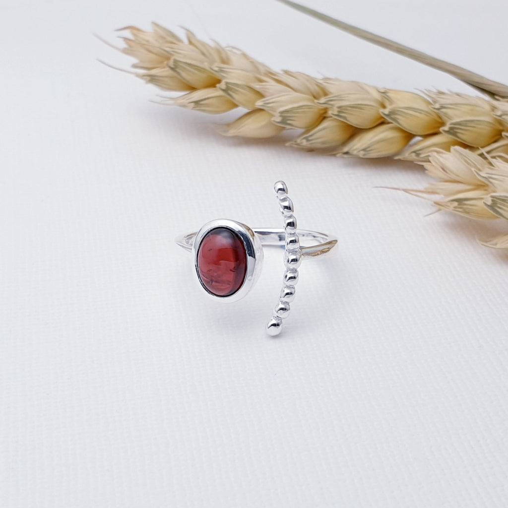 Our Garnet Sterling Silver Bubble Open Ring is perfect for everyday wear or special occasions.  This ring features a beautiful, cabochon, oval, Garnet stone in a simple Sterling Silver setting. Open at the front, this ring wraps beautifully around the finger, with the Garnet stone on one side and a gorgeous curved bubble design on the other.