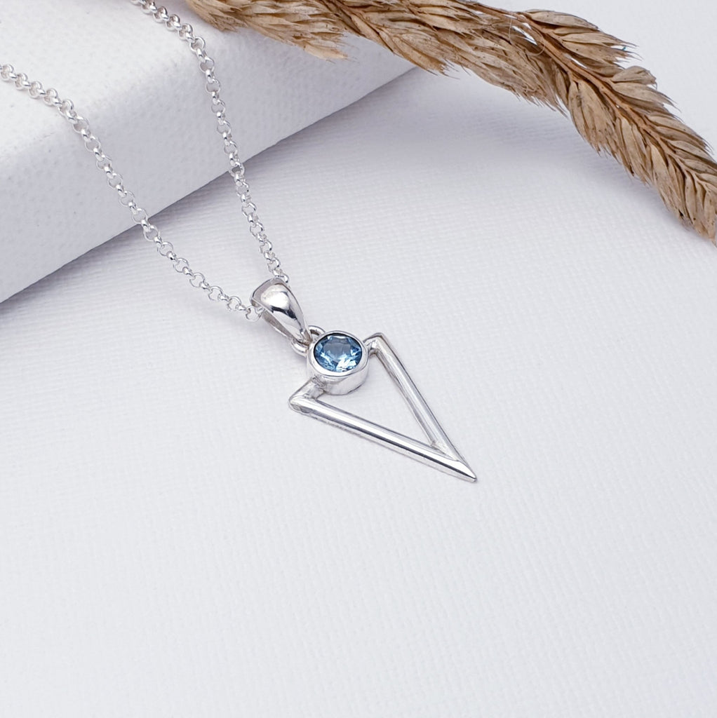 Our Blue Topaz Acute Triangle Pendant (chain not included) is perfect for everyday wear or special occasions.  This pendant features a beautiful tabletop-cut Blue Topaz set above a cut out, acute triangle design, hand worked in Sterling Silver. A fabulous geometric pendant, perfect worn on its own or layered with other necklaces creating your own unique look.