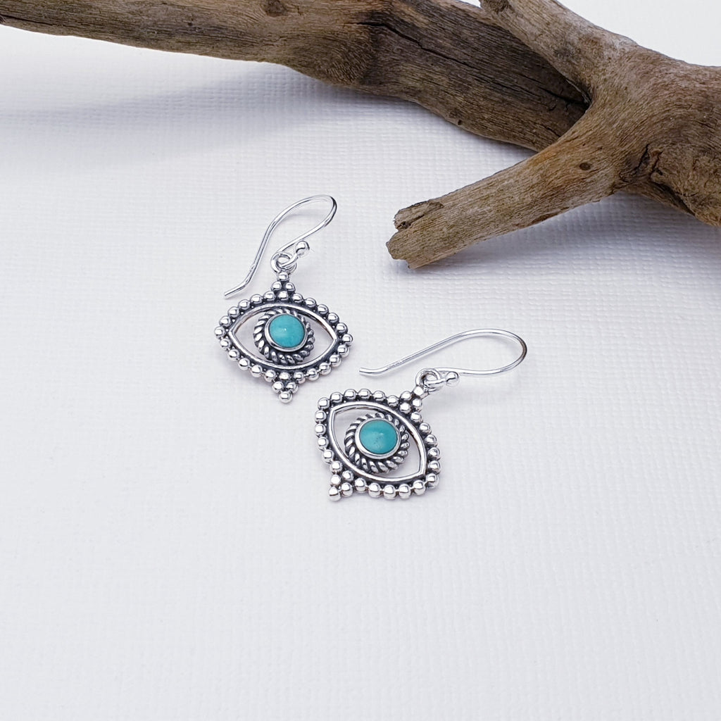 Our Turquoise Sterling Silver Eye Earrings are perfect for everyday wear or special occasions.  Give your look a touch of boho vibes with our exquisite Turquoise Sterling Silver Eye Earrings! Featuring a round, Turquoise stone in a Sterling Silver eye shape, these earrings will spice up your outfit and add the perfect amount of sparkle. 