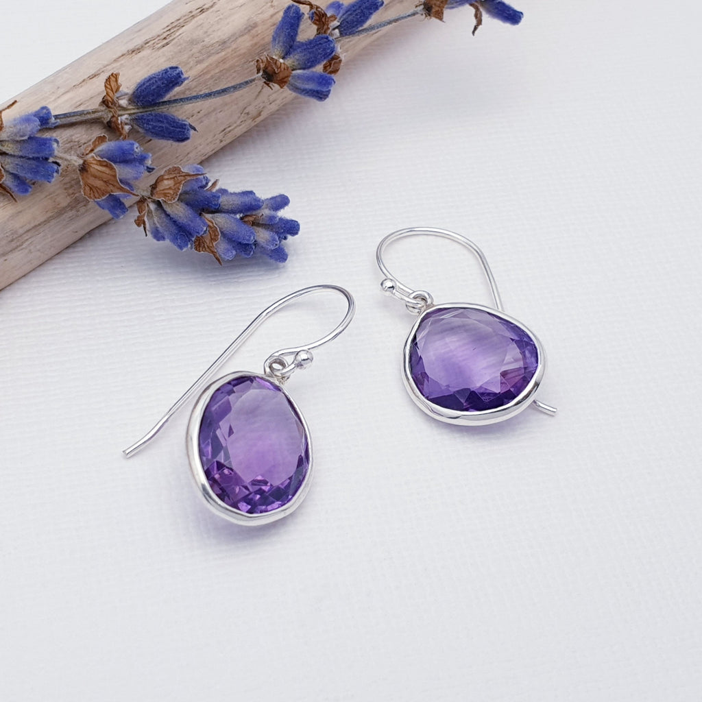 These earrings feature beautiful tabletop cut, free form, Amethyst stones in simple Sterling Silver settings. Each earring is completaly unique, the silver has been skillfully worked around the individual shape of each stone, therefore no two earrings are the same.