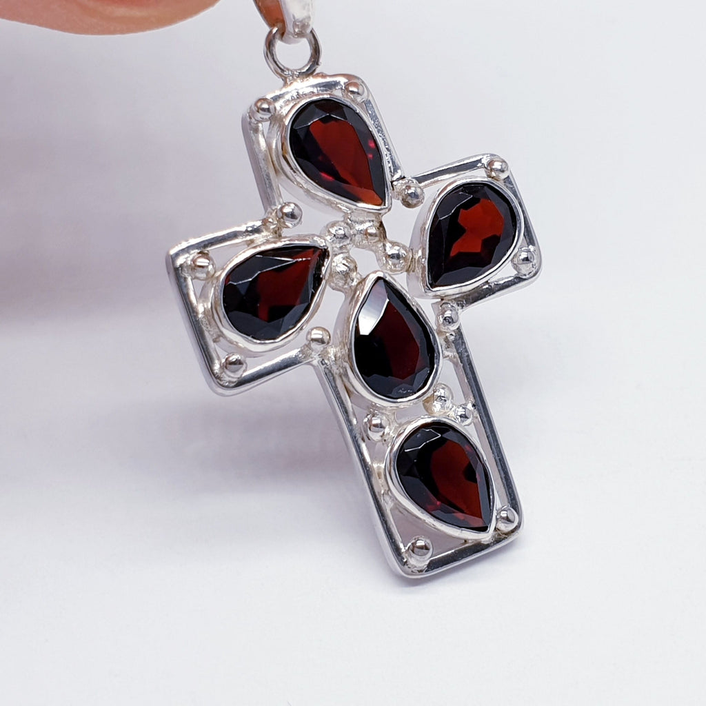 sterling silver cross pendant with garnet teardrop gemstones.