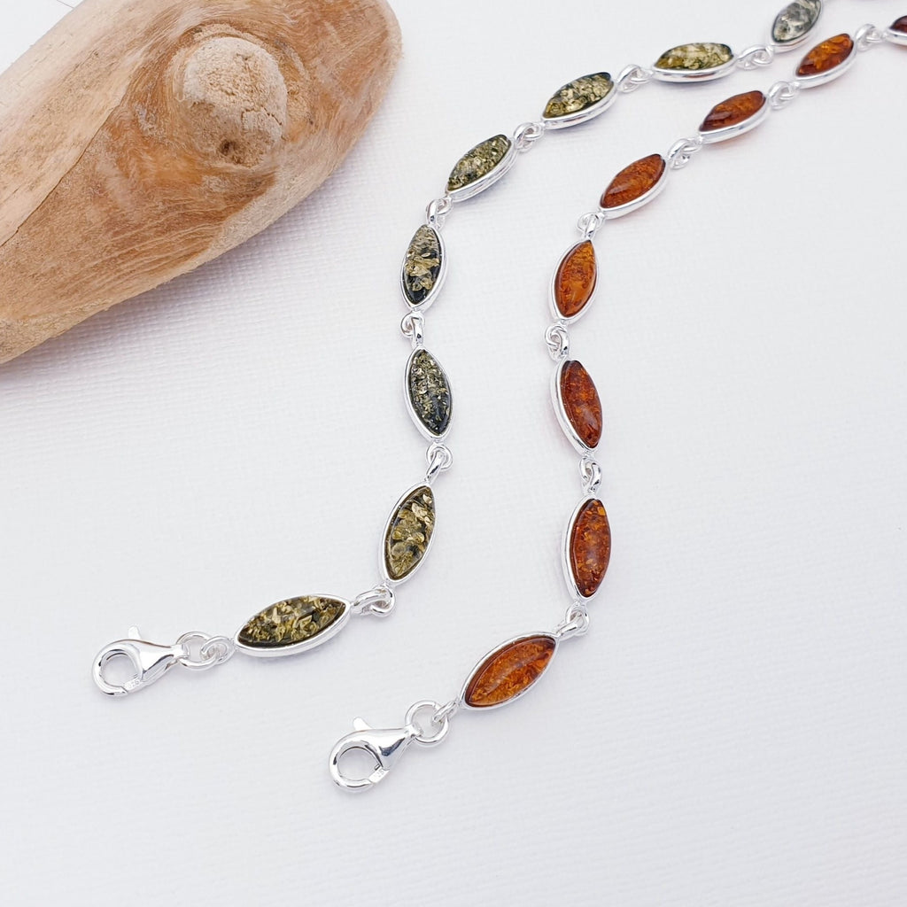 A Toffee and a Green Amber Sterling Silver Bracelet with marquise shaped stones. Dainty and elegant. pictured with driftwood.