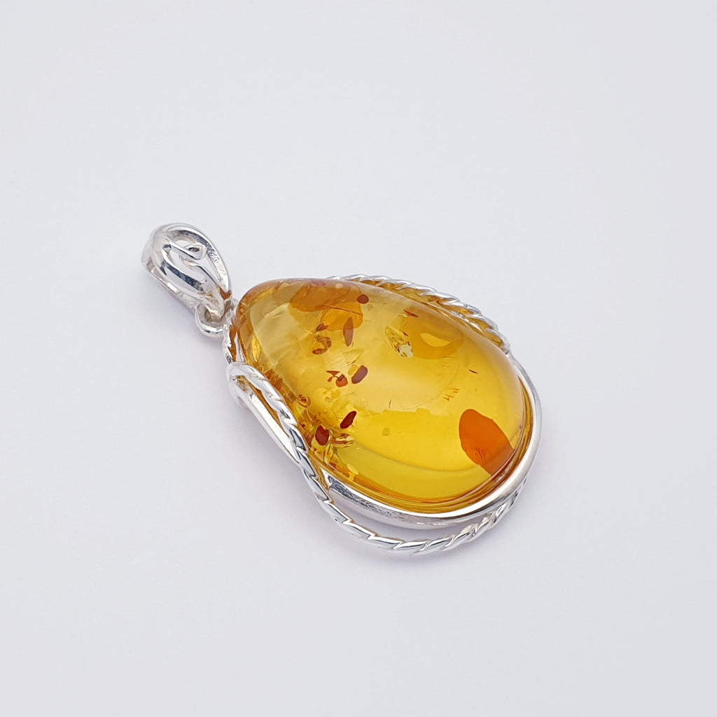 large toffee amber pendant with sterling silver rope style setting.