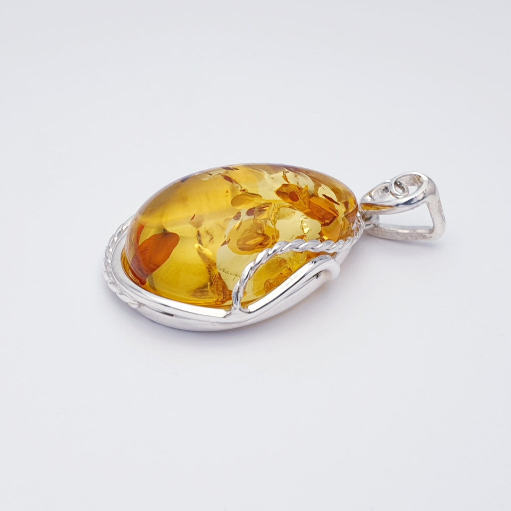 large toffee amber pendant with sterling silver rope style setting.
