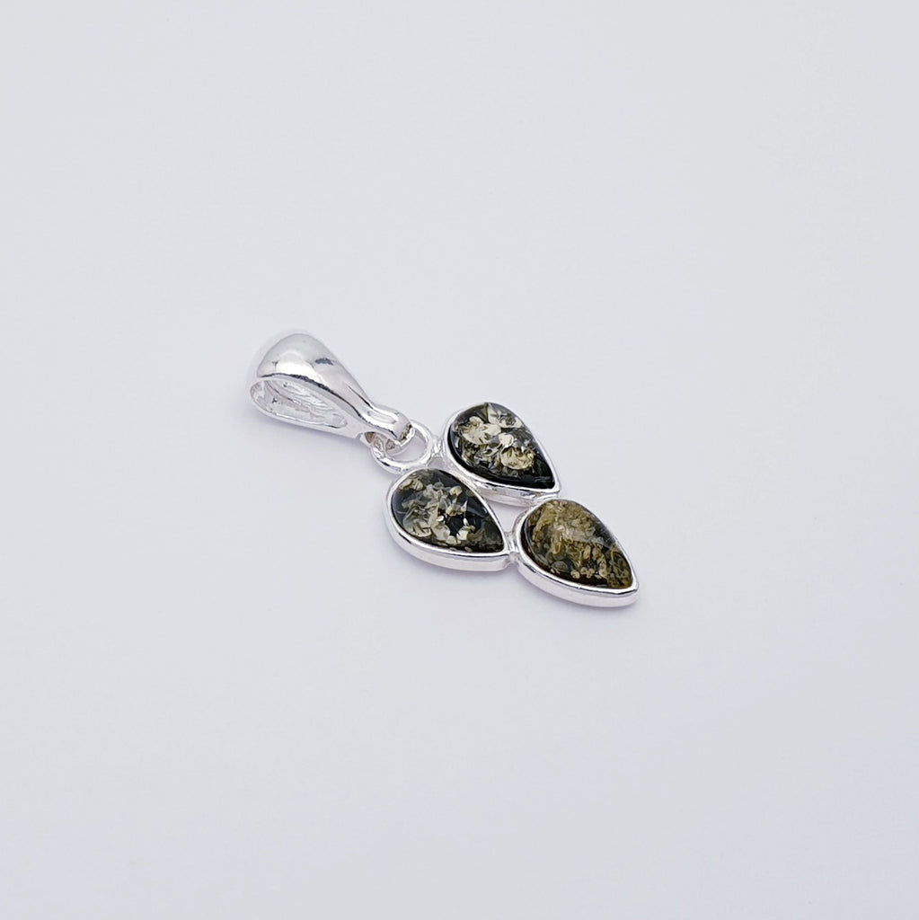 a green amber pendant with three teardrop shaped gemstones in a sterling silver setting