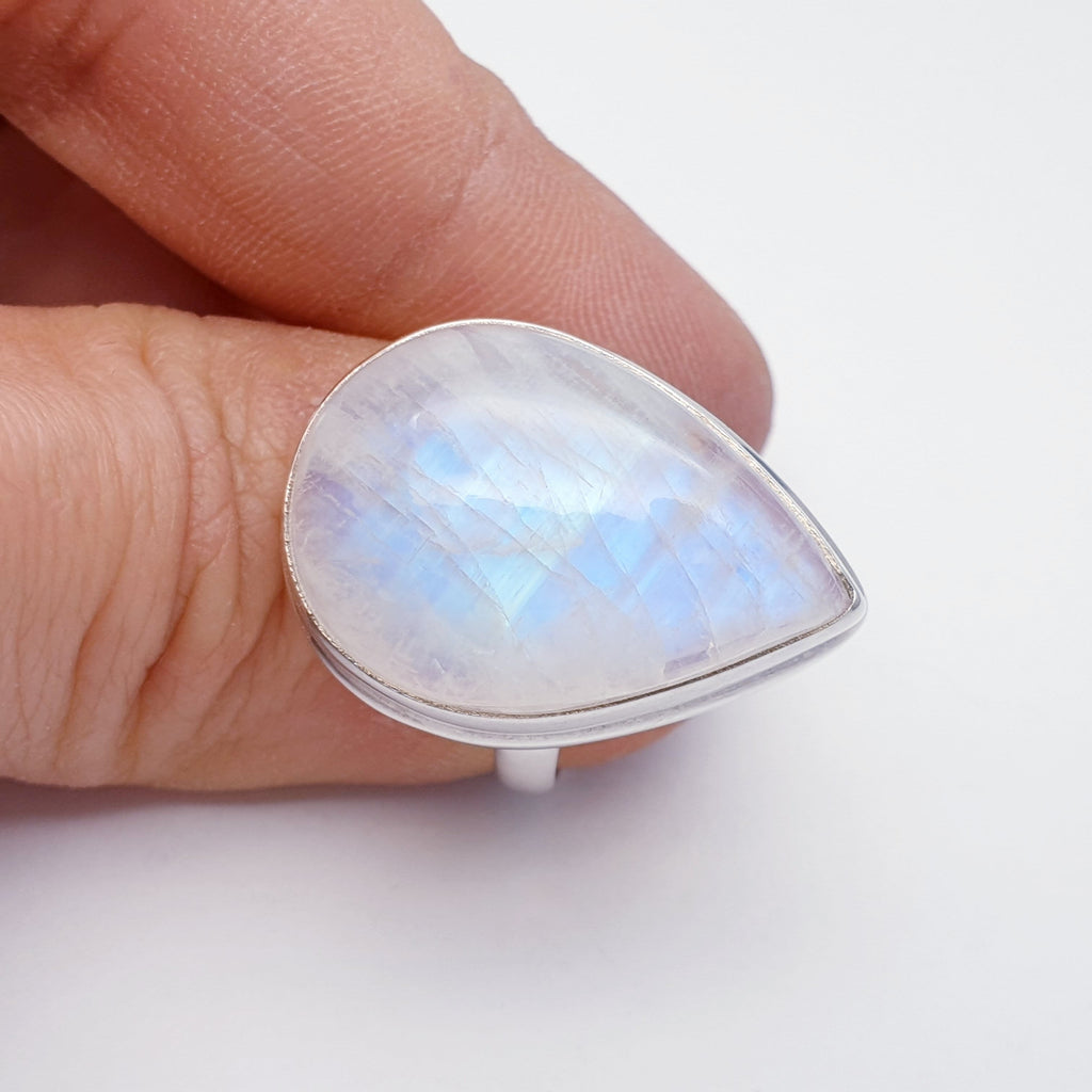 Large teardrop shaped moonstone ring on a thumb