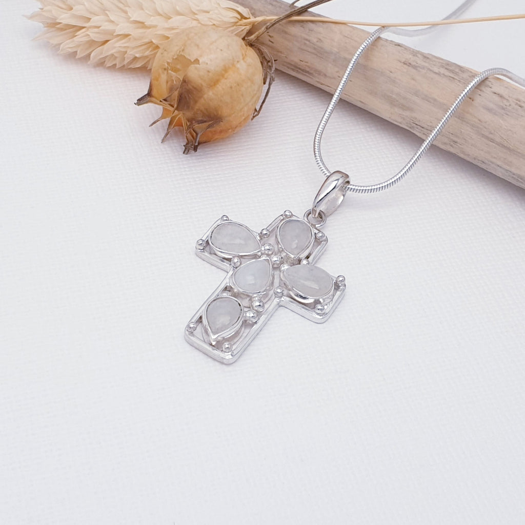 Sterling silver cross pendant with teardrop moonstone gemstones on a chain with petal foliage