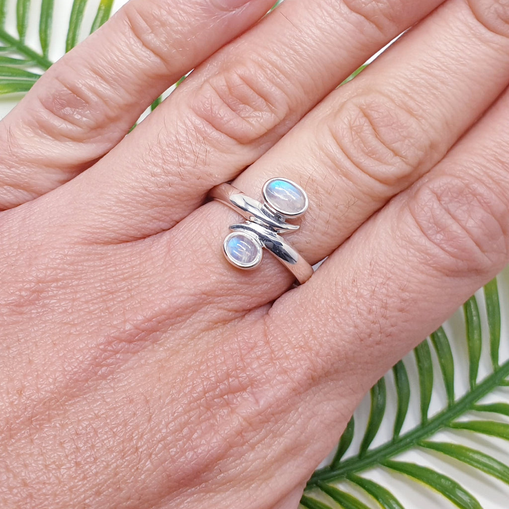 Double moonstone gemstone and sterling silver ring on a hand