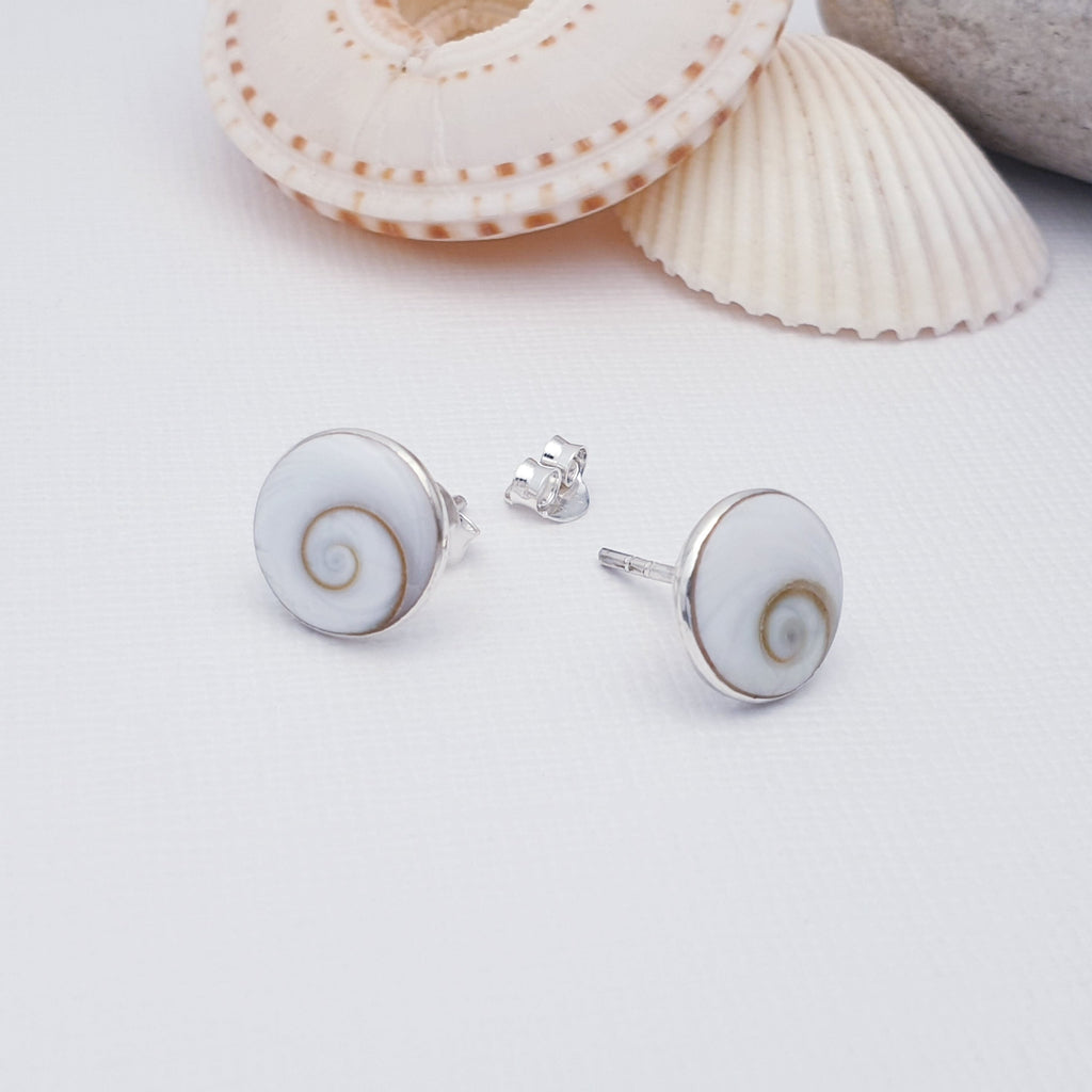 two white sea shell sterling silver studs with shells behind