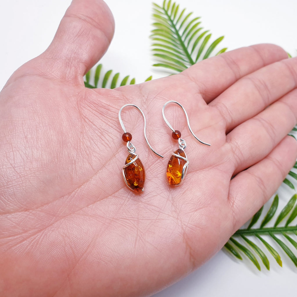 Amber Gisela earring on a hand to show the size