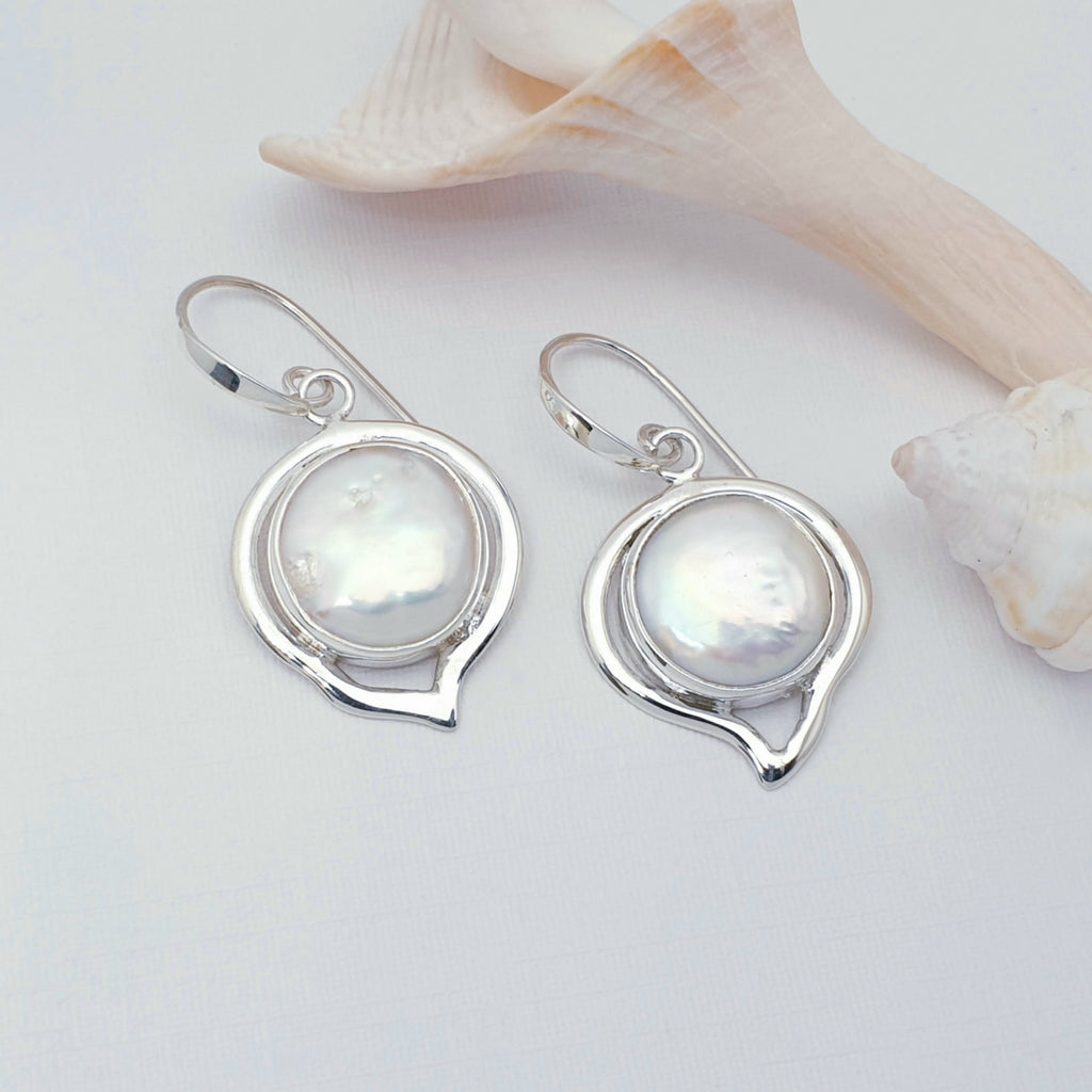 Keshi pearl and sterling silver earrings, displayed on a white background with shells as decoration