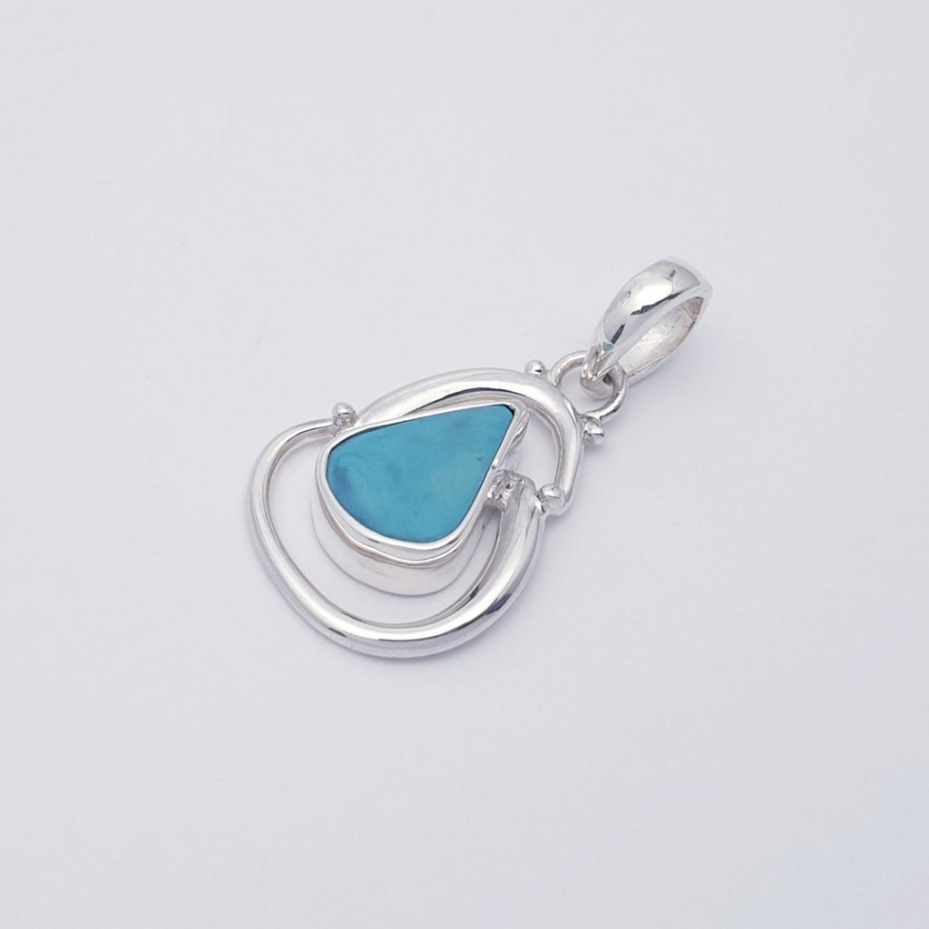 Handmade turquoise gemstone pendant with swirling sterling silver design