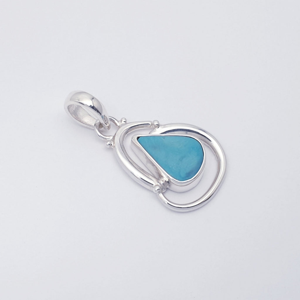 Handmade turquoise gemstone pendant with swirling sterling silver design