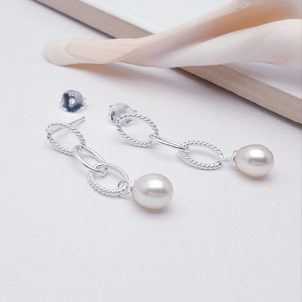 sterling silver and pearl stud earrings displayed on a white background