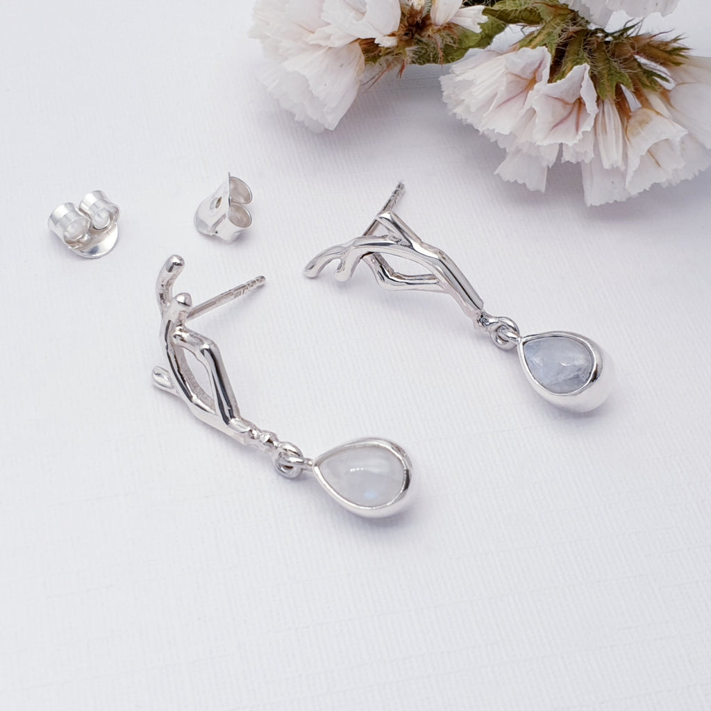 Moonstone sterling silver vine earrings on a white background with white foliage details