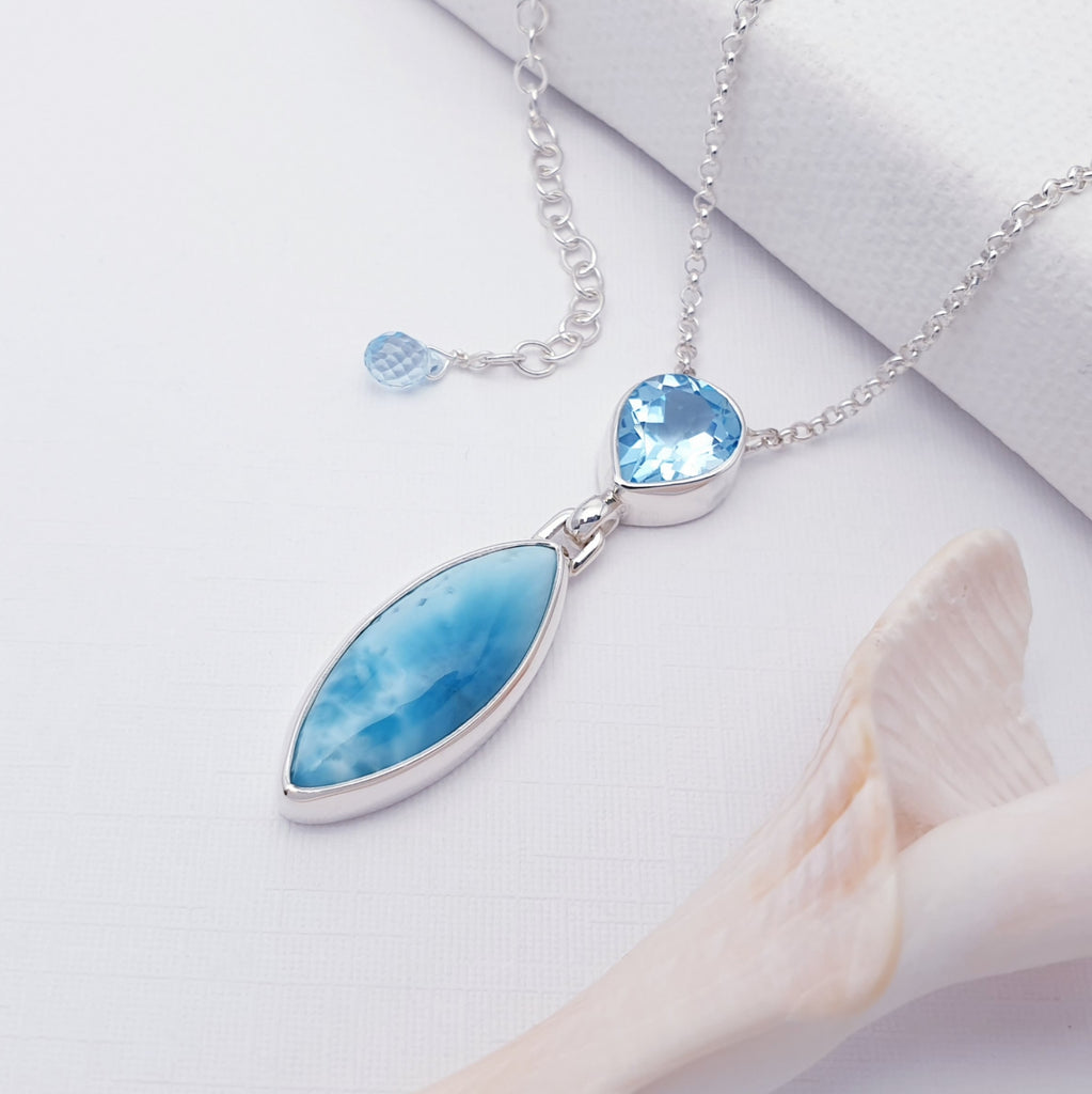 Larimar and Blue Topaz Sterling Silver Andromeda Necklace on a white background with shell details in the bottom right corner