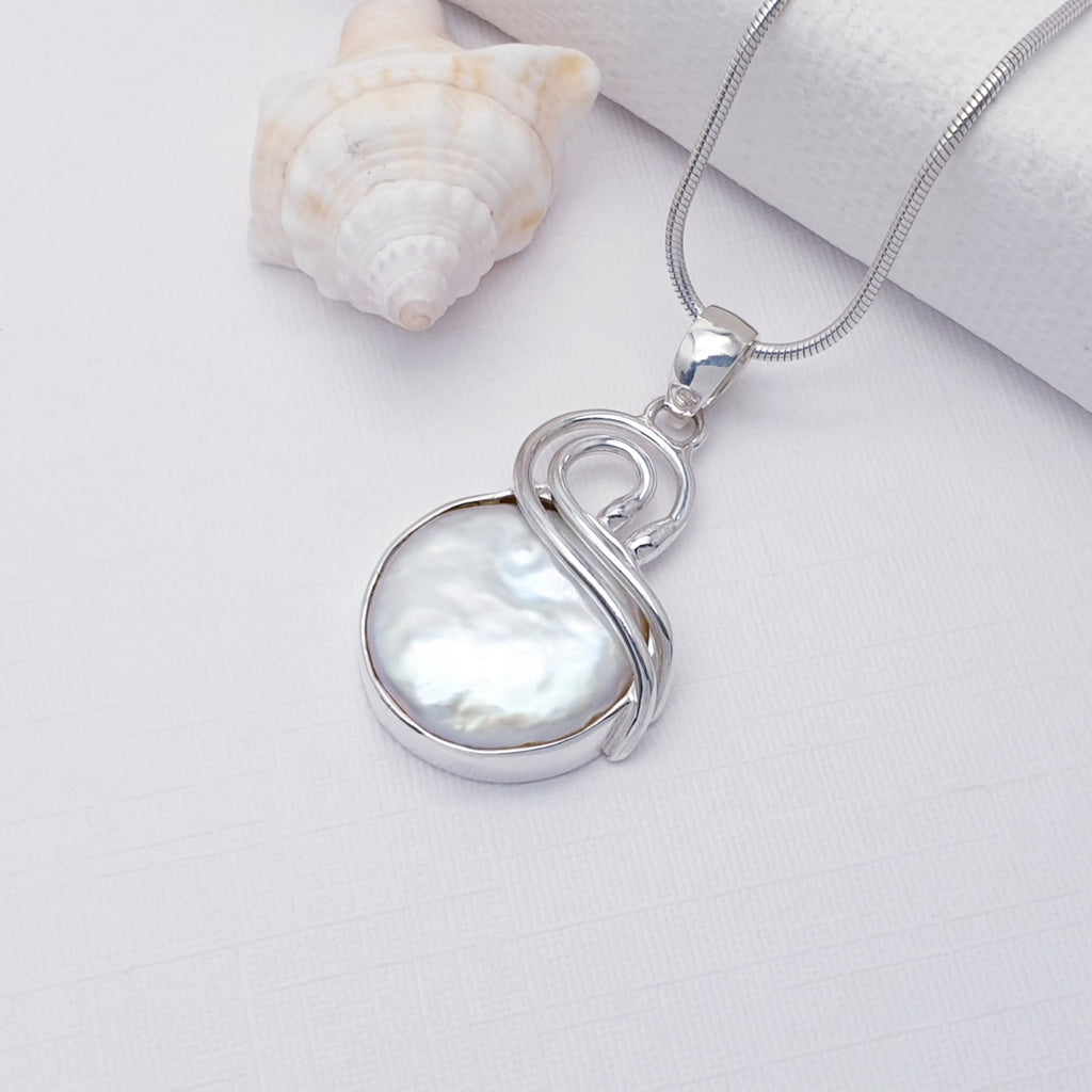 Keshi Pearl Cora Pendant on a Fine Snake Chain which is on a white background with a shell in the top left corner. 